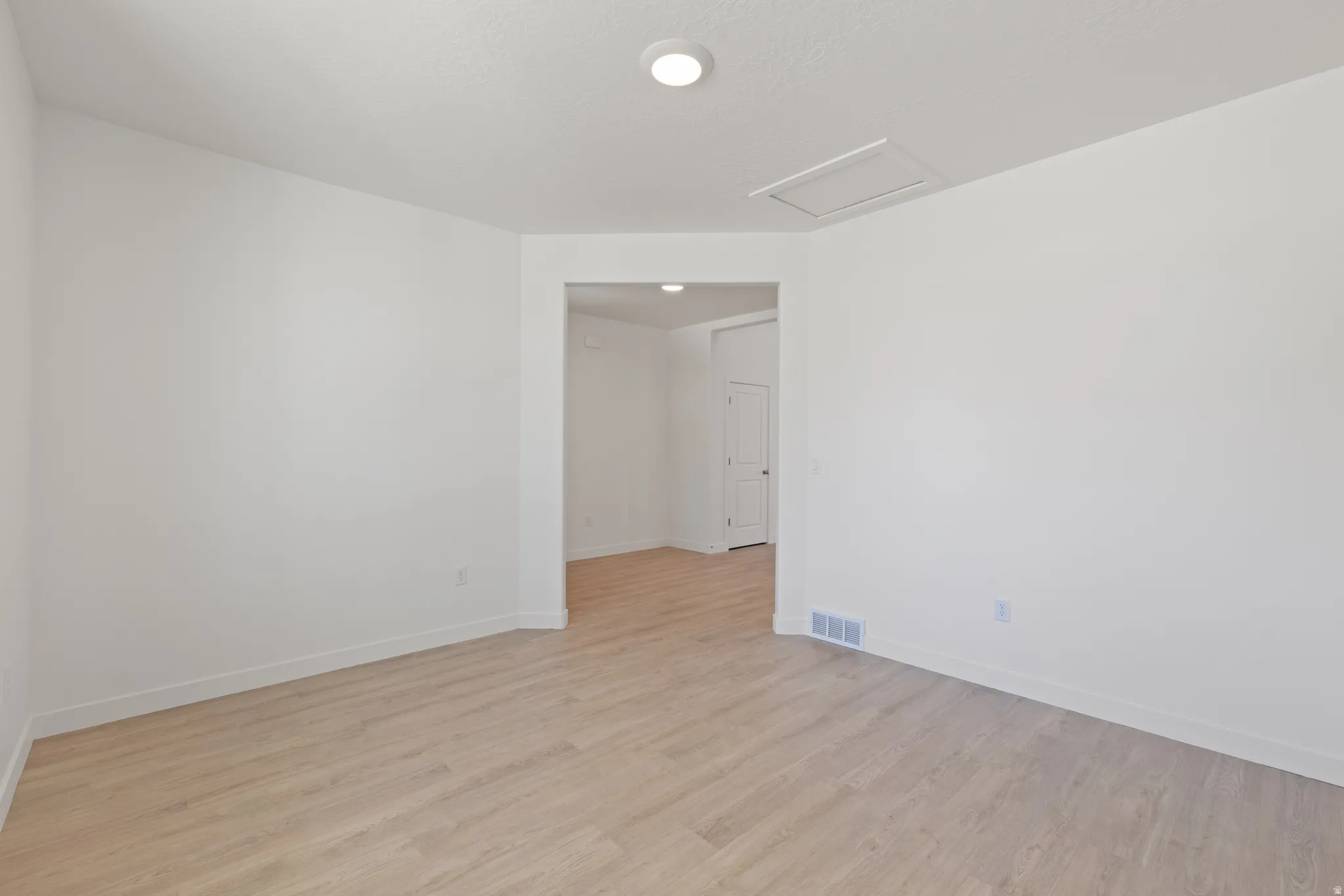 Open concept room featuring light wood-finish flooring, white walls, and recessed lighting