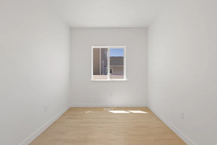 White wall finishes and wood-finish flooring with a single window