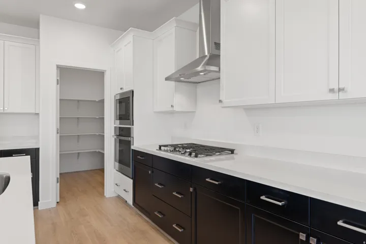 Modern kitchen featuring two-tone cabinetry with white upper and dark lower units
