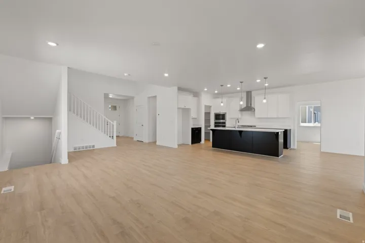 Expansive open-concept living space with wood-finish flooring
