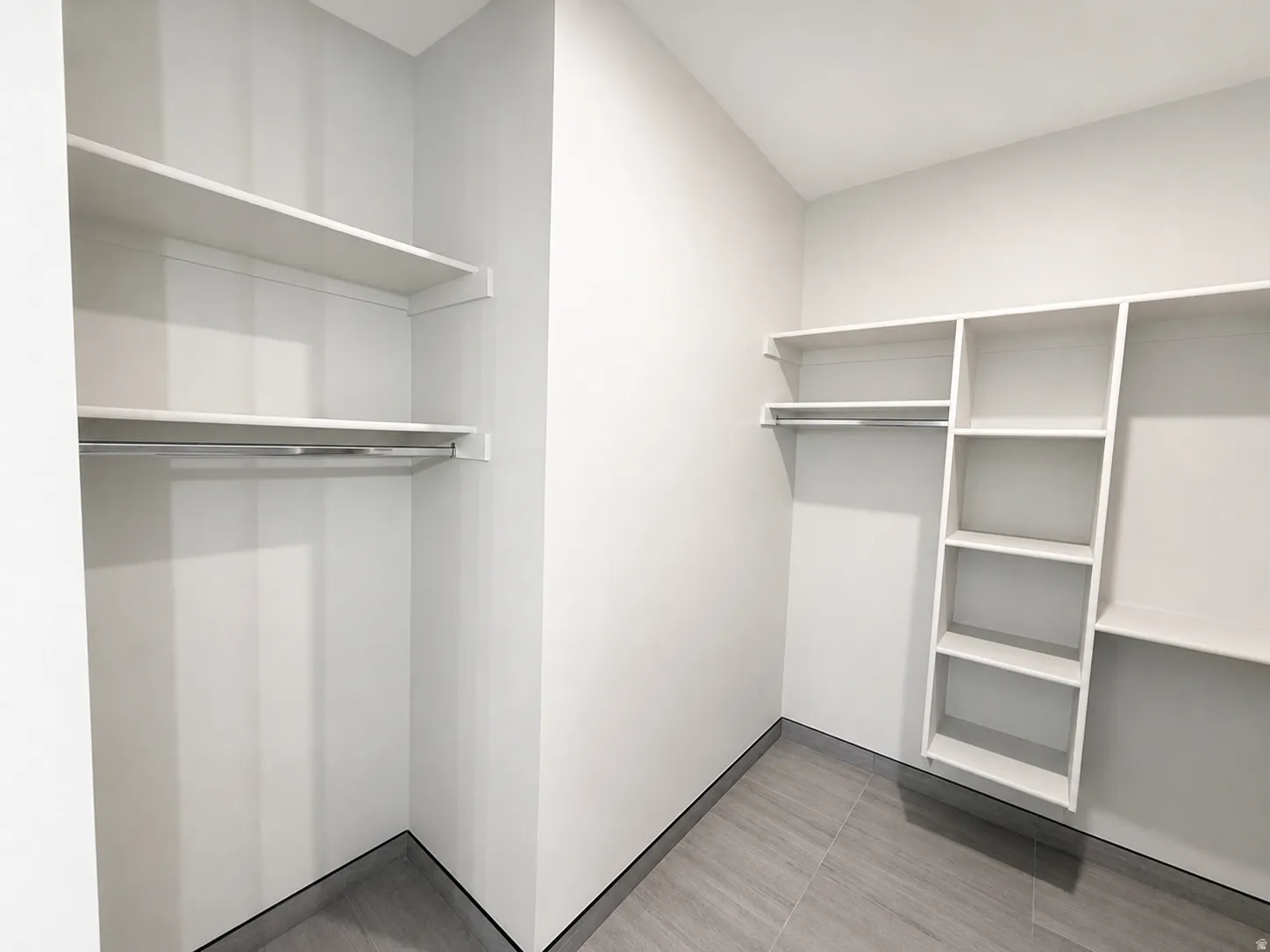 Walk-in closet featuring light gray tile flooring and white shelving