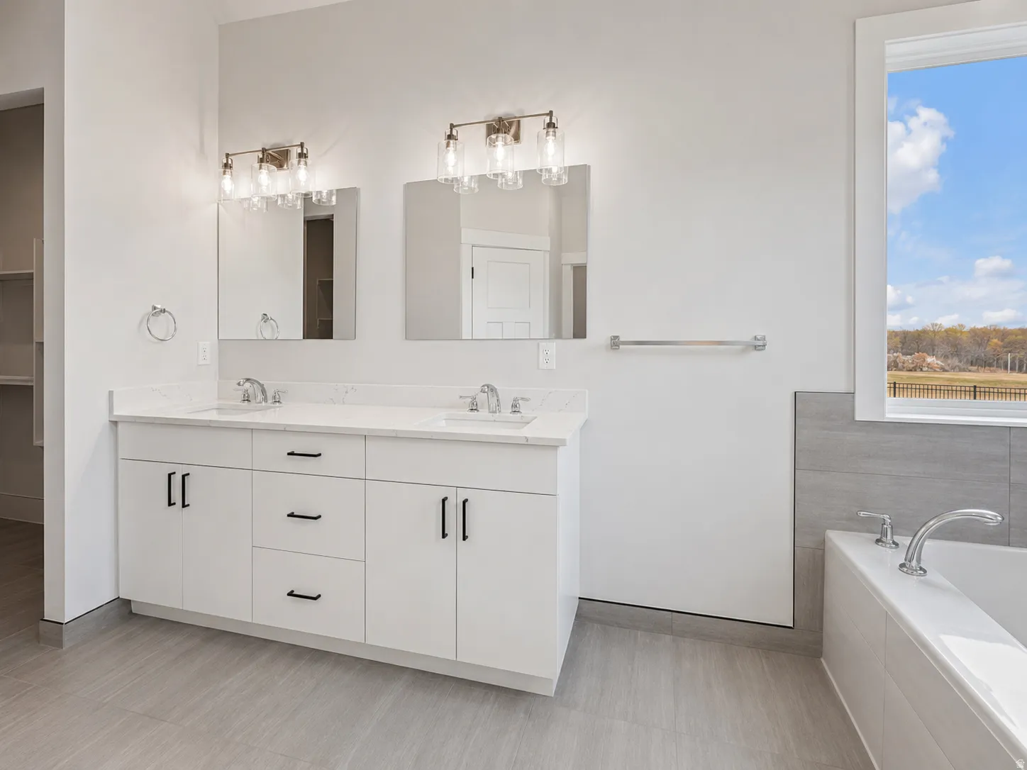 Dual vanity with white cabinetry, quartz countertops, and brushed nickel fixtures