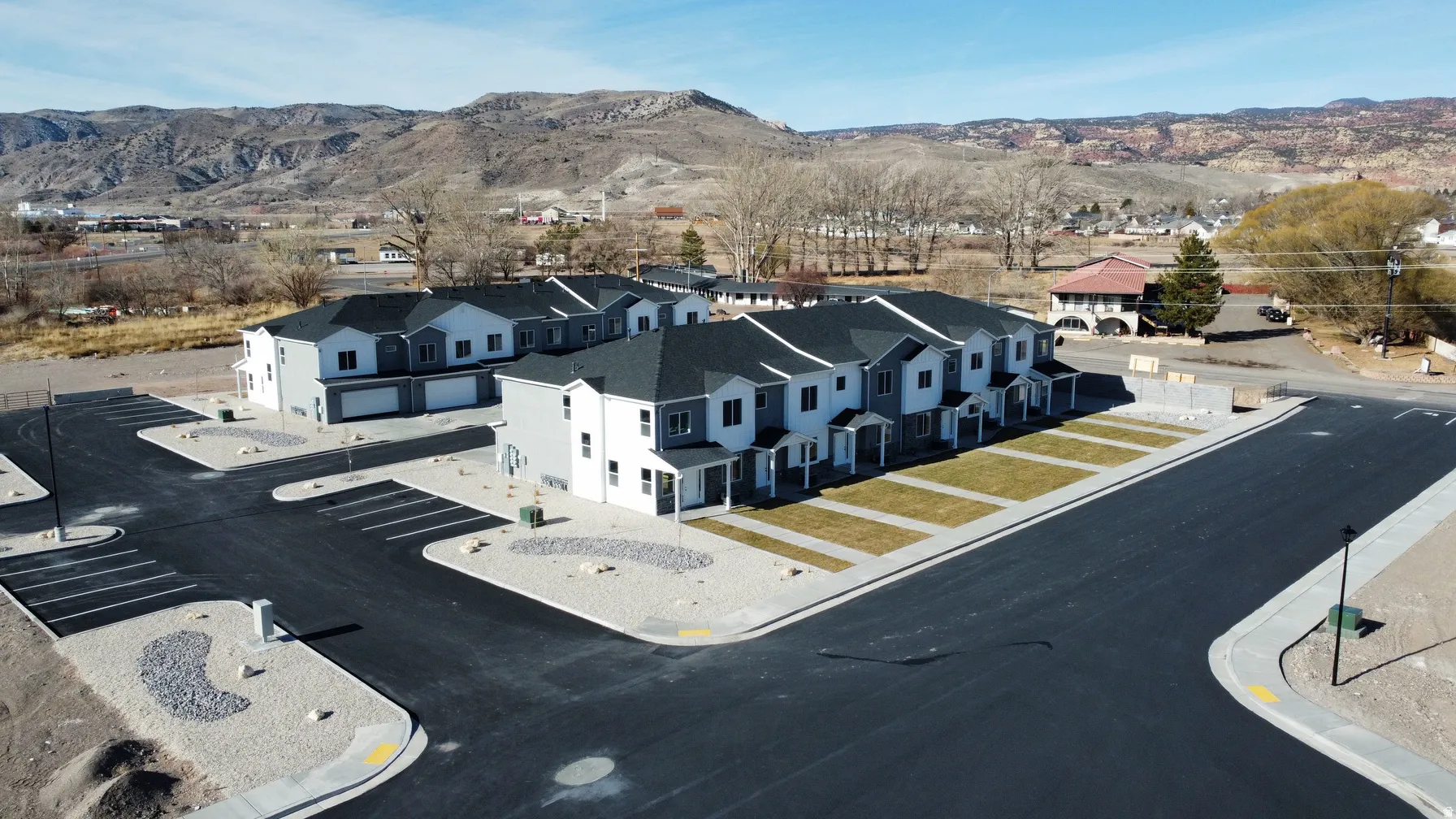 Modern townhome development with a combination of light and dark siding and dark shingle roofing