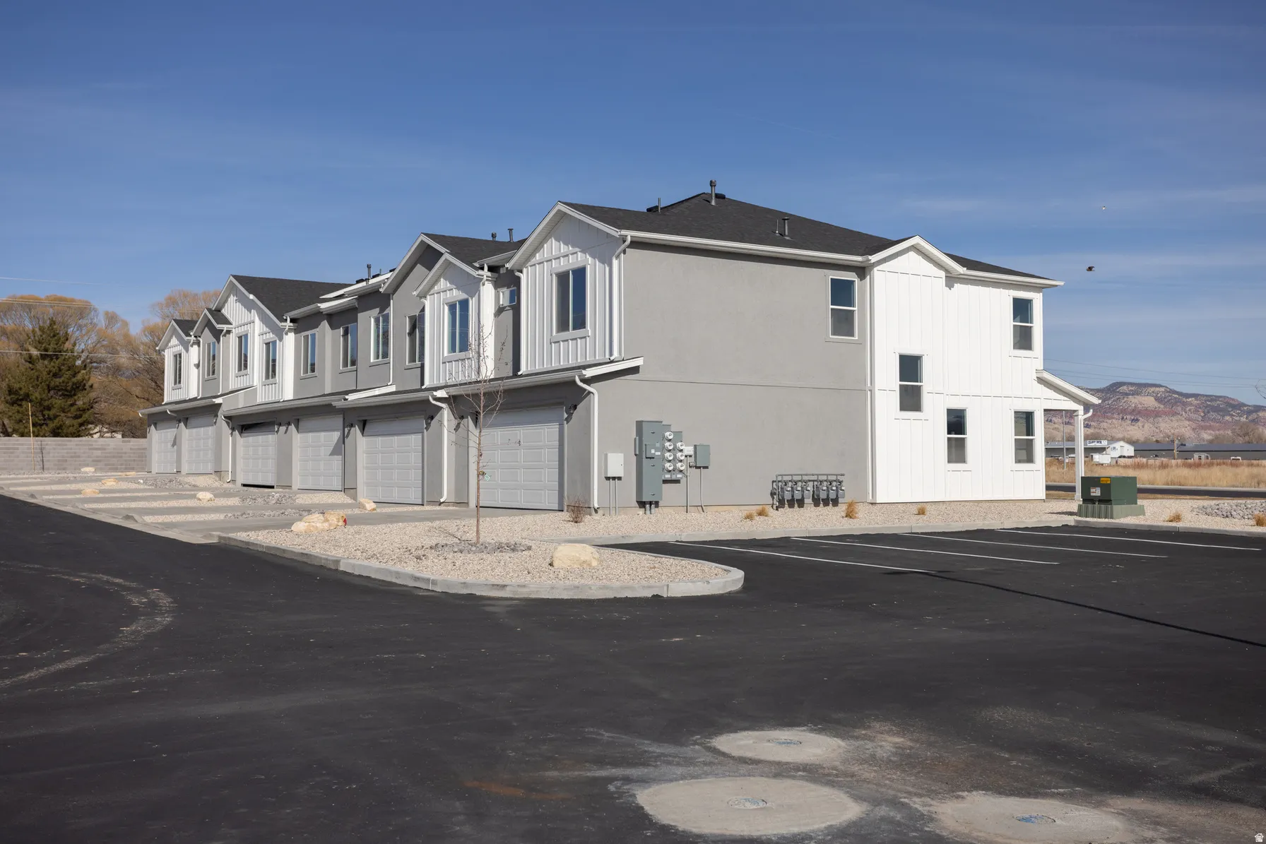 Contemporary townhome exteriors featuring gray stucco and white vertical siding accents