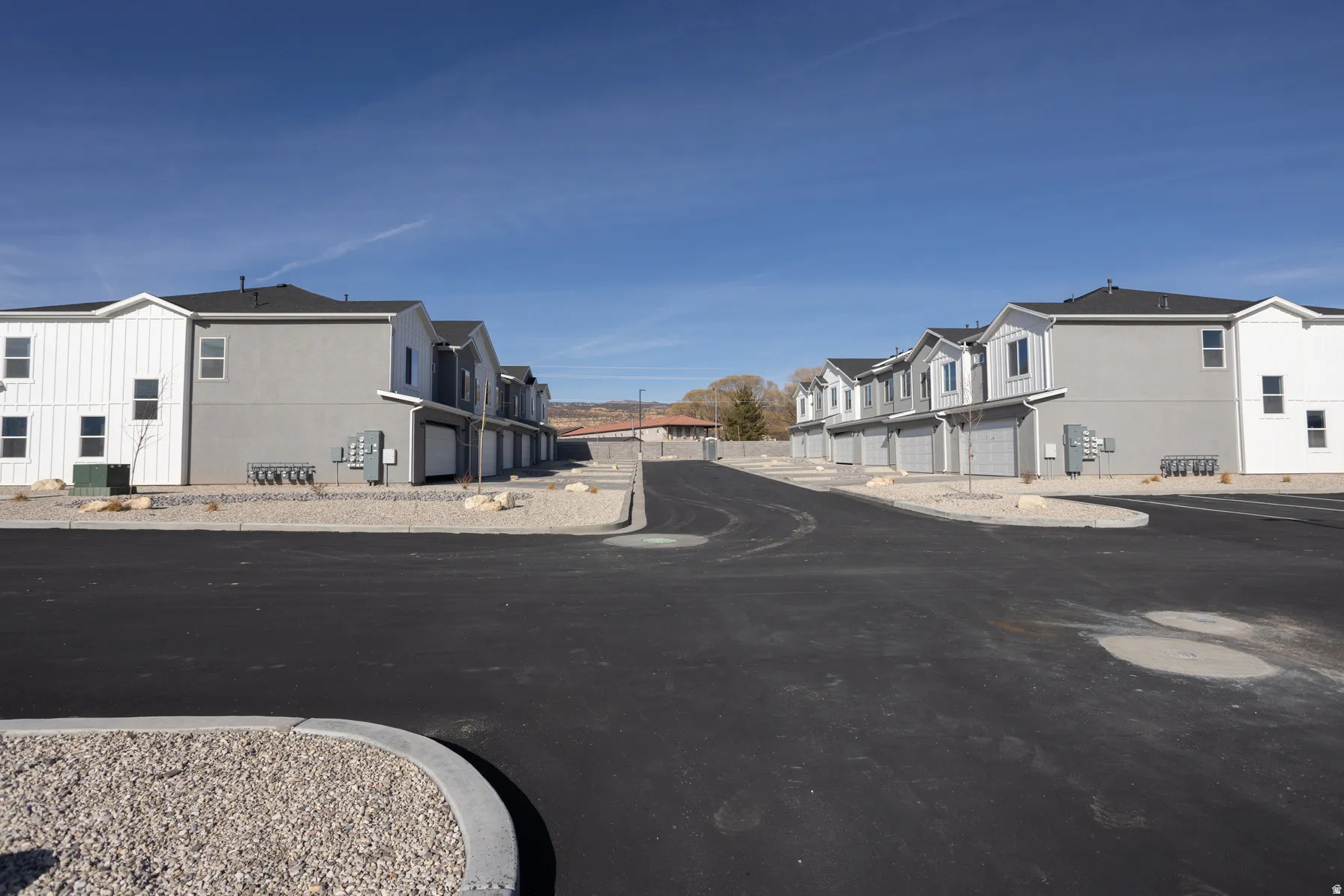 Newly constructed two-story townhomes featuring modern siding in white and gray tones