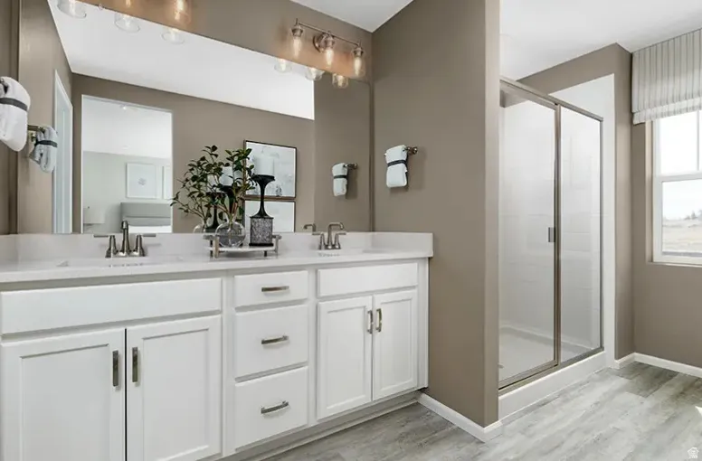 Dual vanity with white shaker cabinetry, brushed nickel hardware, and a light-toned countertop