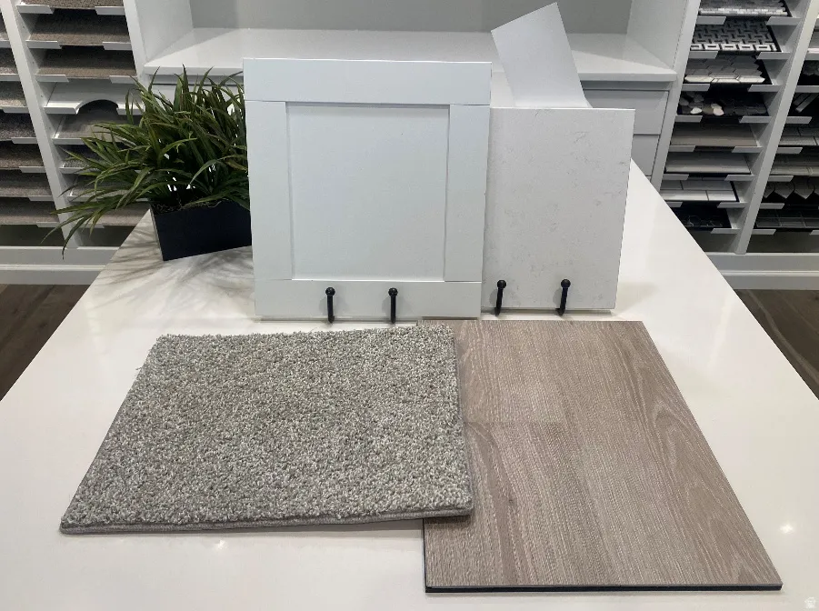 Contemporary material selection featuring a white shaker cabinet door, light-toned wood-finish flooring, a light gray carpet sample, and a white countertop sample