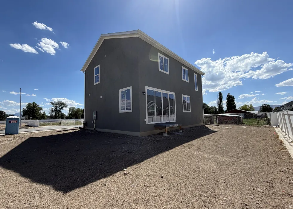 Two-story structure featuring a dark gray stucco exterior and white trim