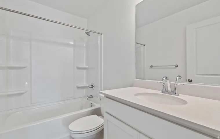 White vanity with integrated sink, chrome faucet, and expansive mirror