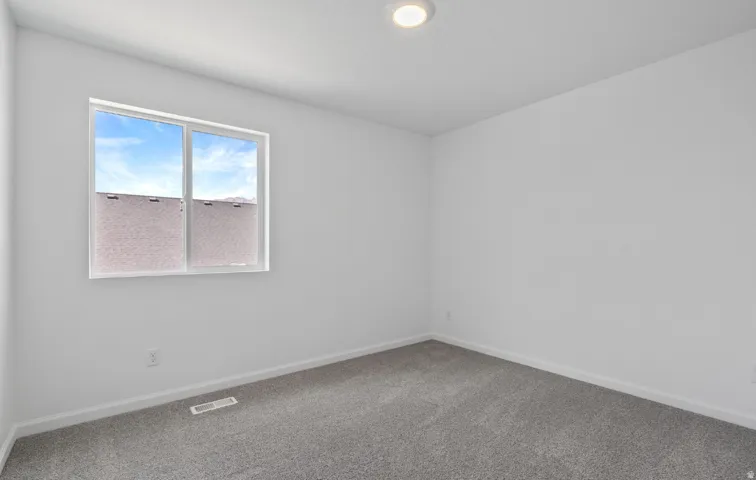 Recessed ceiling lighting, gray carpet, and a large window