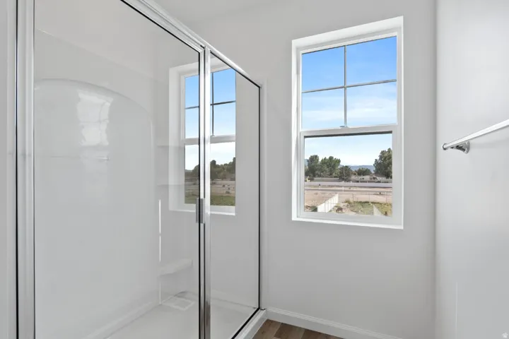 Glass-enclosed shower with integrated seating and bright window