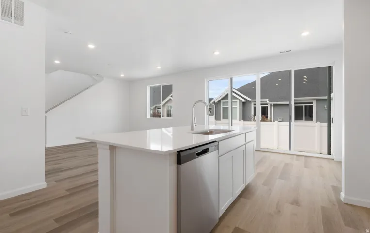 Central island with a stainless steel sink and integrated dishwasher