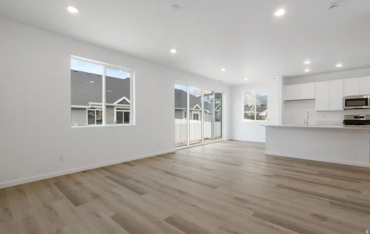Open-concept living space featuring wood-finish flooring, recessed lighting, and white walls