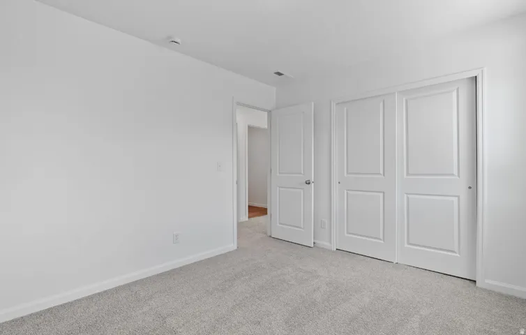 Gray carpeting, white walls, white paneled doors, and ceiling