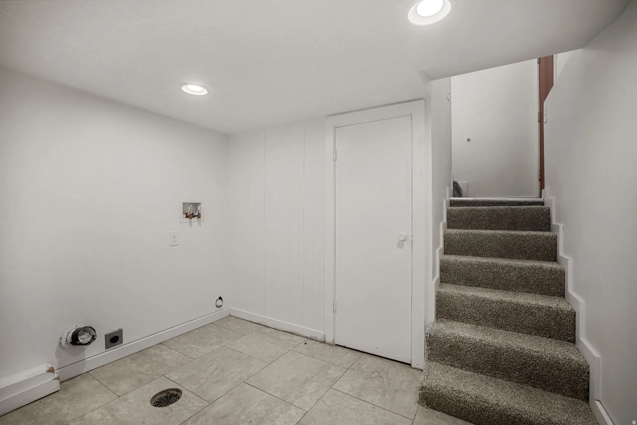 Lower level utility area featuring recessed lighting, tiled flooring, and laundry hookups