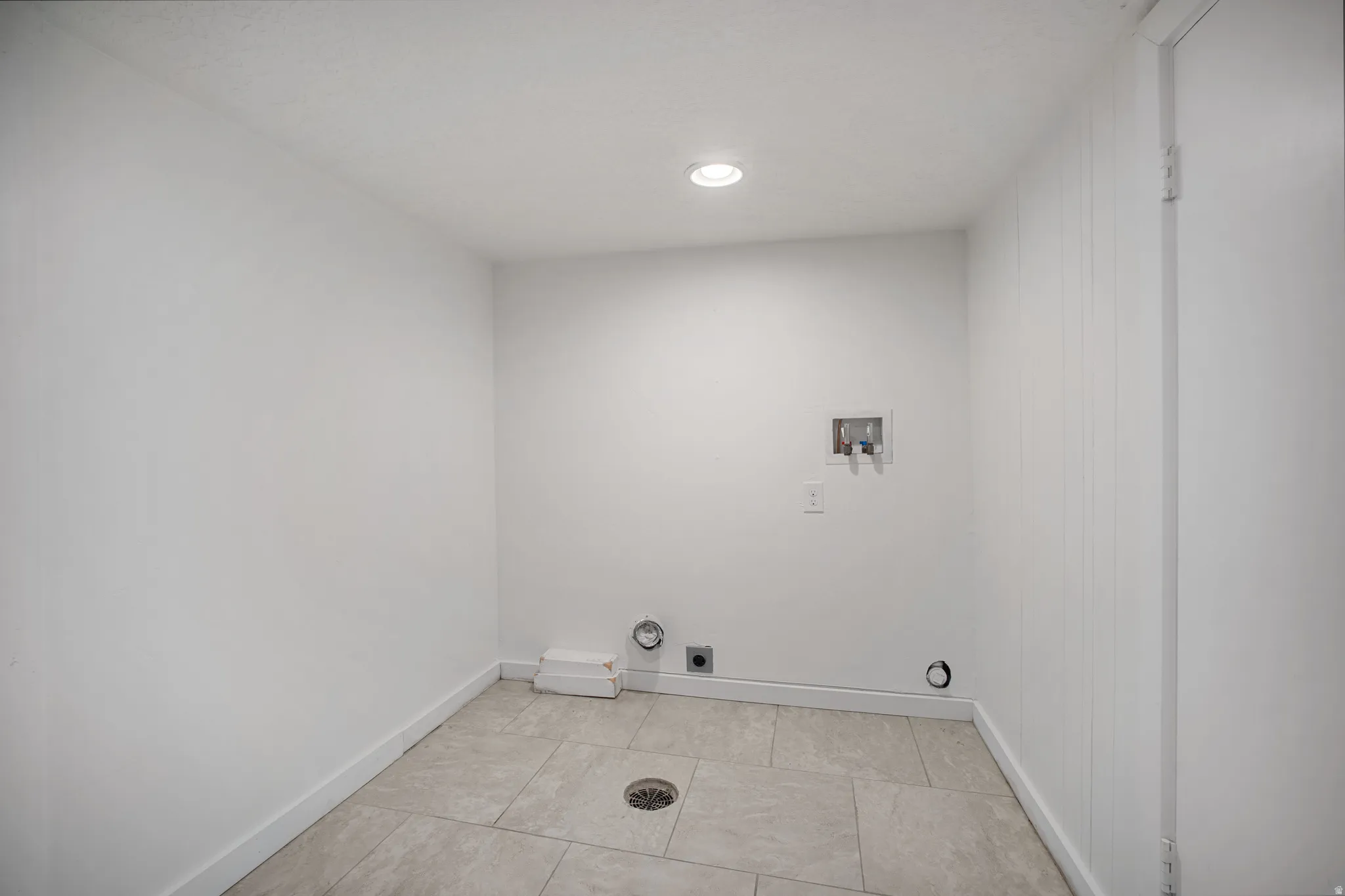 Dedicated utility space featuring tile flooring, white walls, and recessed lighting