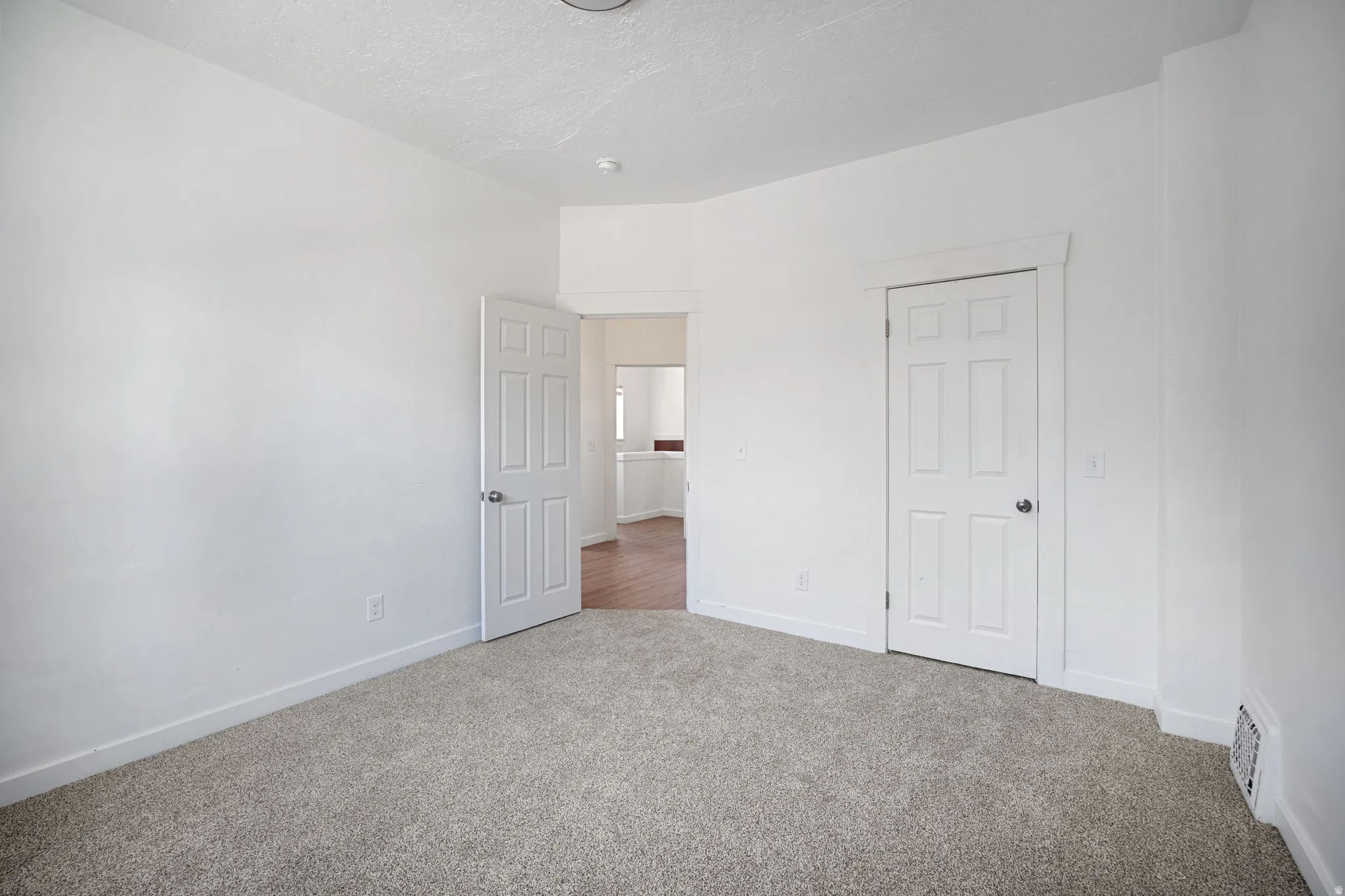 Room featuring neutral gray carpet, white painted walls, and white trim