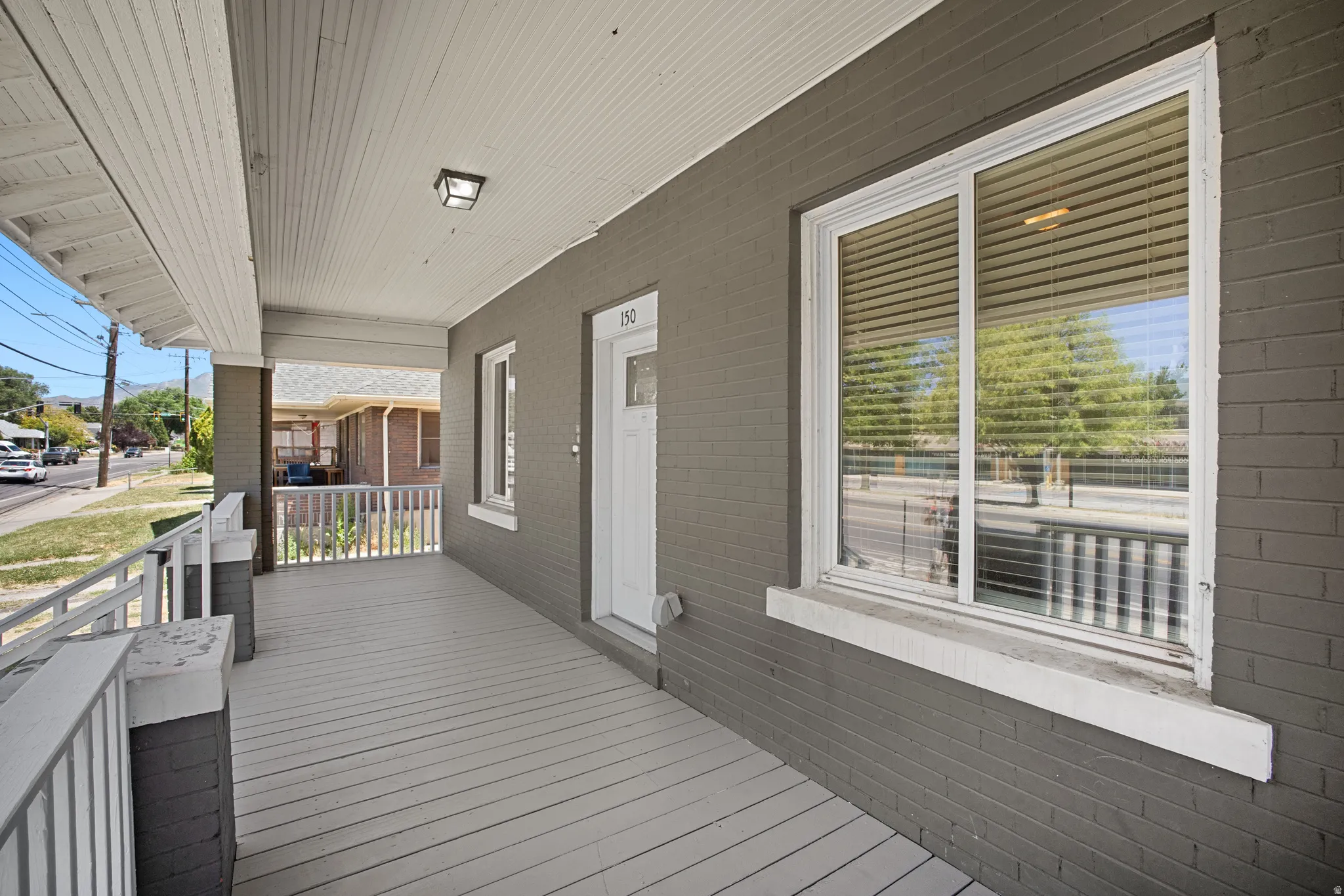 Inviting covered front porch with painted wood-finish flooring
