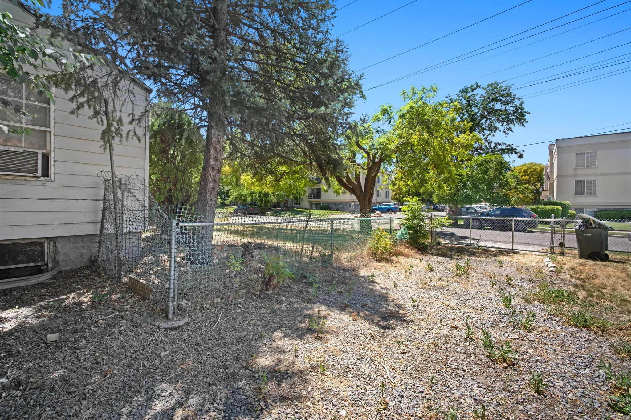 Gravel ground cover with a chain-link fence bordering the street