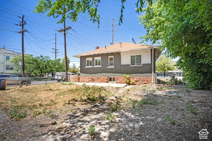 Residential property featuring a neutral-toned exterior with white trim windows and a red-toned roof