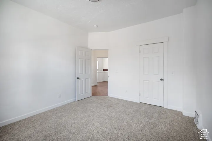 Room featuring neutral gray carpet, white painted walls, and white trim