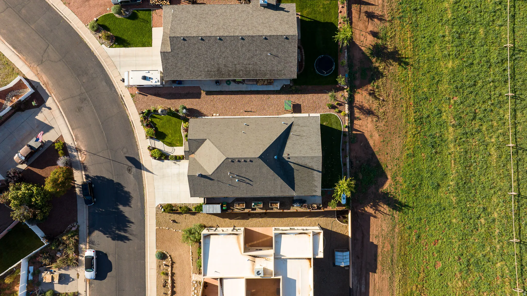 Aerial perspective of a property featuring a multi-gabled roofline and an attached concrete driveway