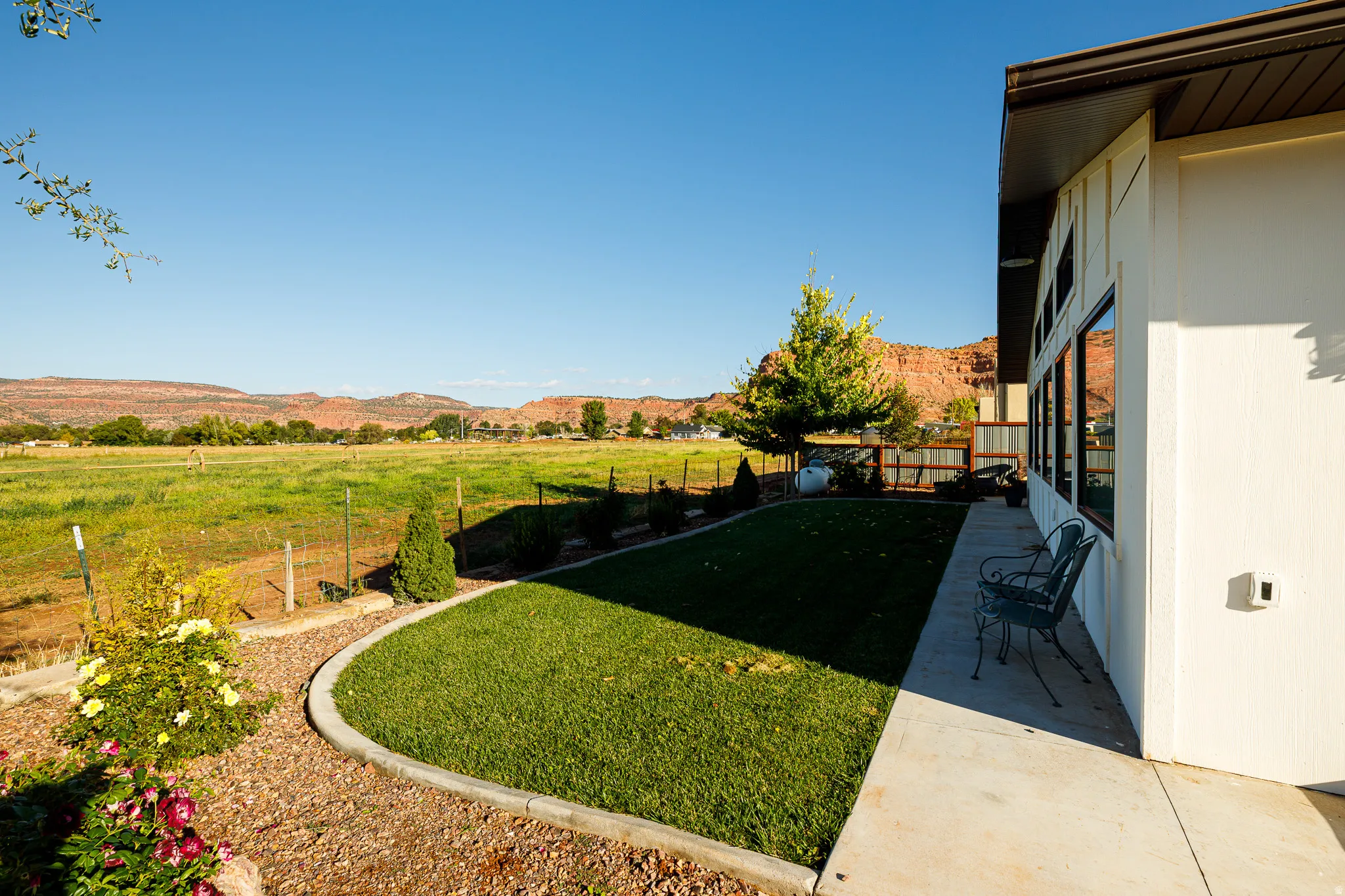 Expansive green field extending to distant red rock formations