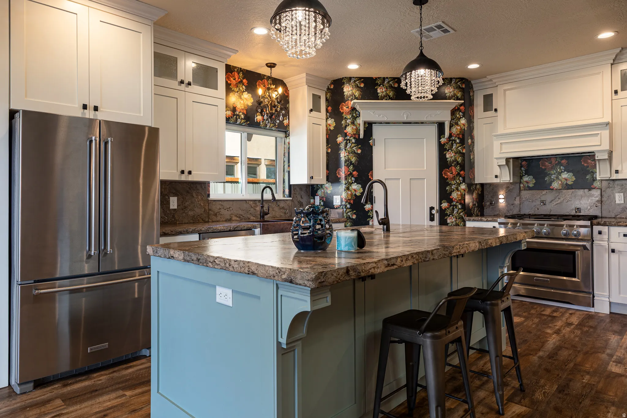 Kitchen featuring a large island with a stone countertop, white shaker cabinetry, stainless steel appliances, and wood-finish flooring