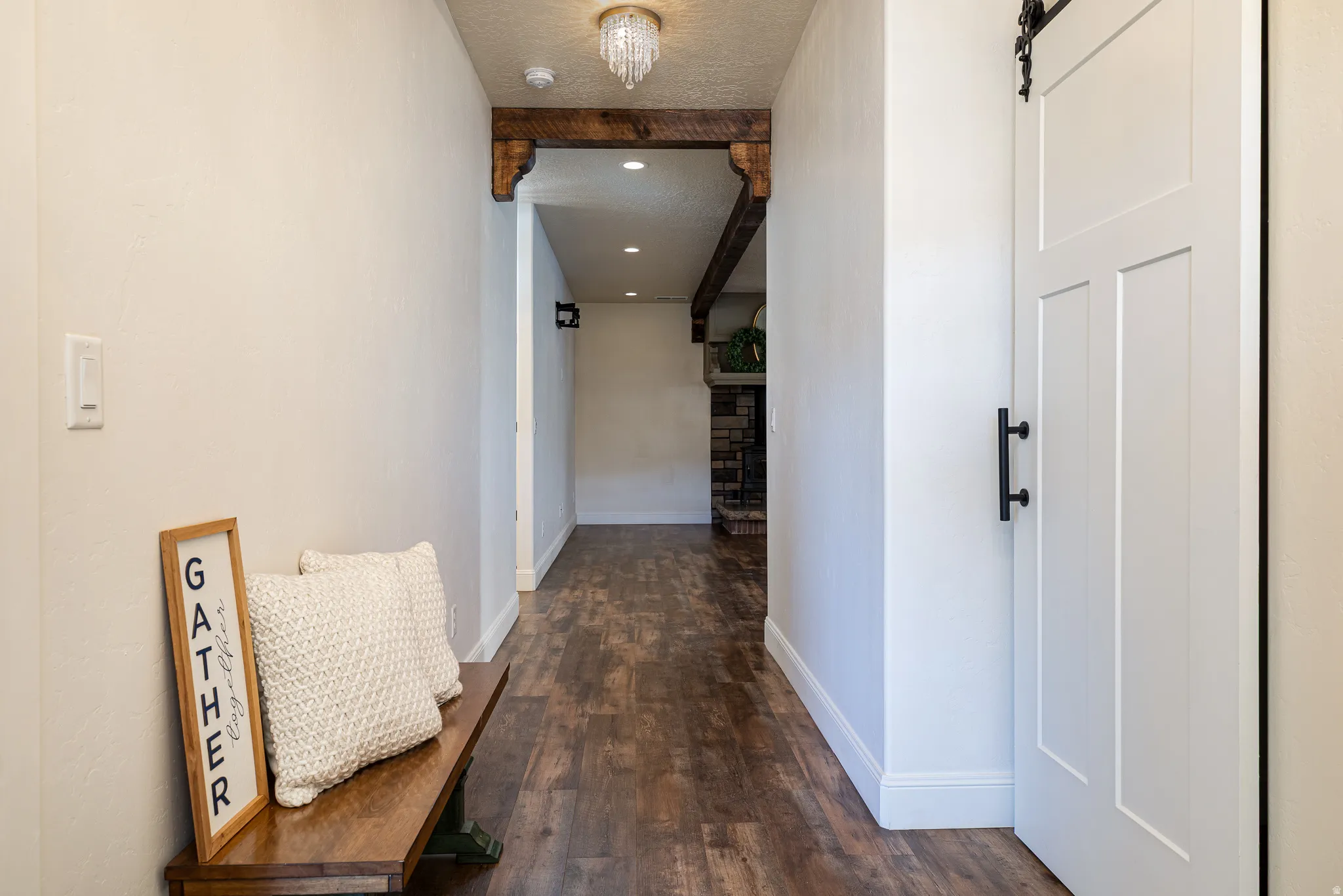 Hallway featuring wood-finish flooring and white baseboards