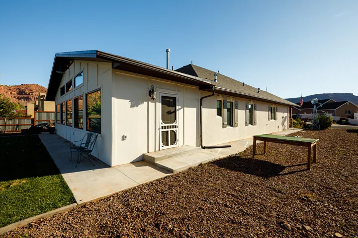Exterior of a property featuring stucco siding and a pitched shingle roof