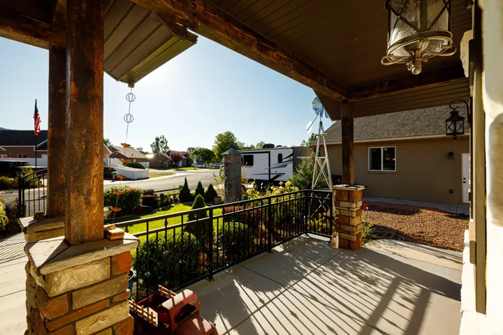 Covered front porch featuring robust wood-finish beams and stone-clad columns