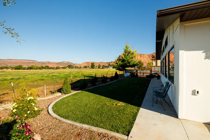Expansive green field extending to distant red rock formations