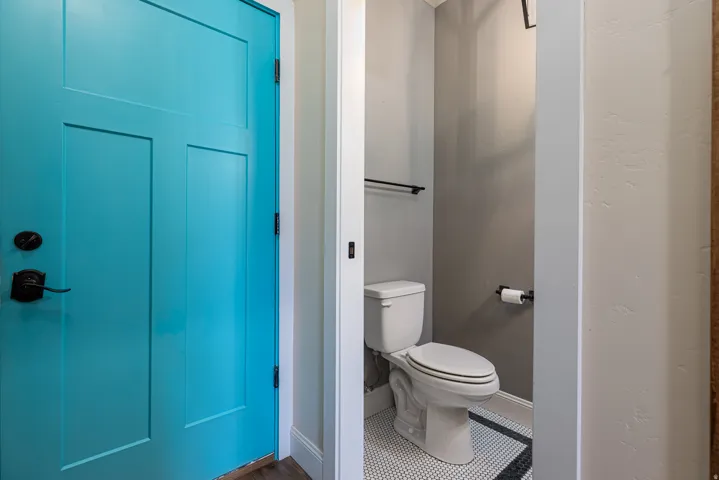 Bold turquoise paneled door with oil-rubbed bronze hardware