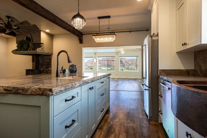 Kitchen featuring an expansive island with a substantial stone countertop and light blue cabinetry