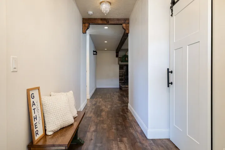 Hallway featuring wood-finish flooring and white baseboards