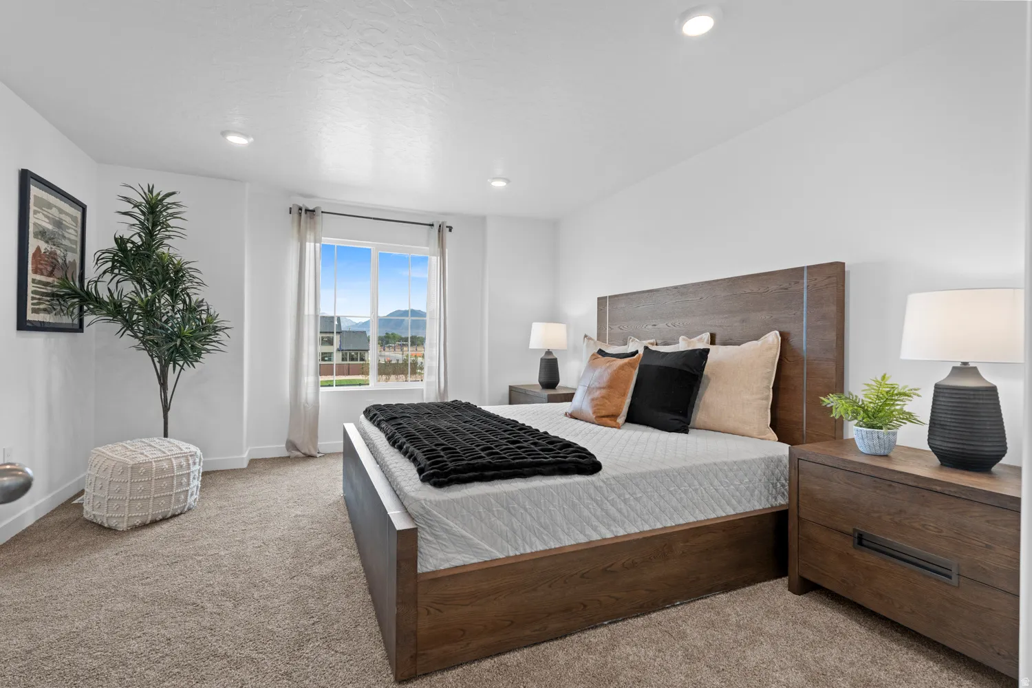 Bright bedroom featuring a large window, recessed lighting, and soft carpet flooring