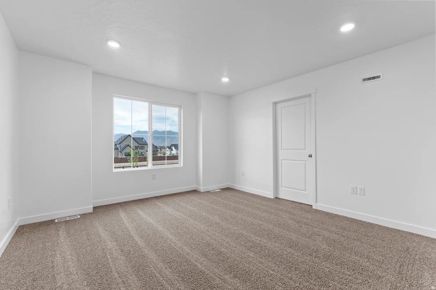 Spacious room featuring new carpet flooring and recessed lighting
