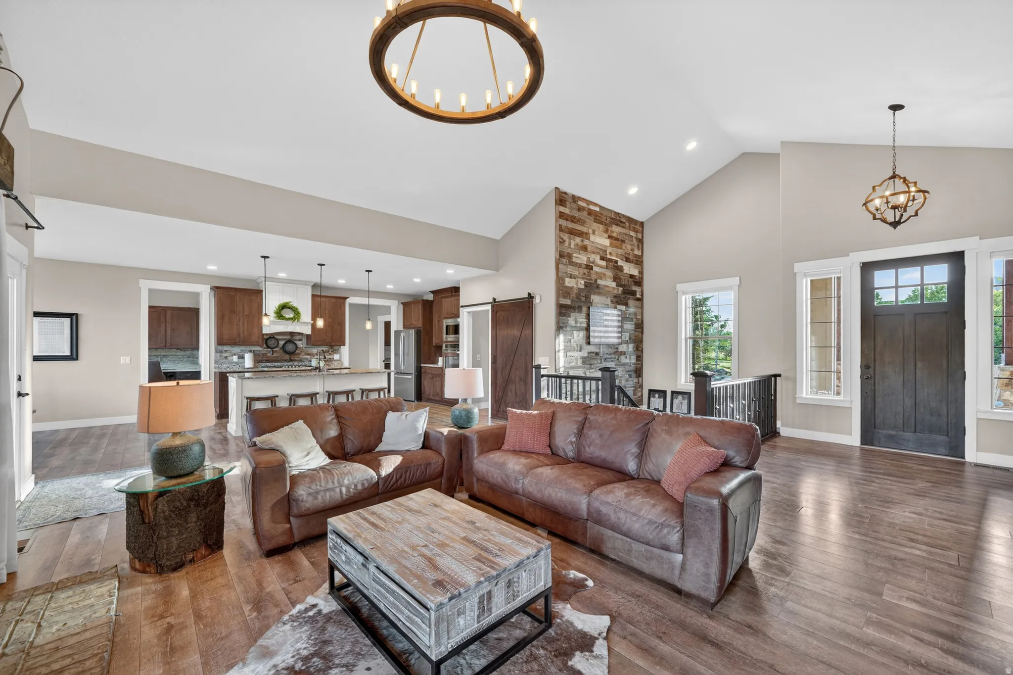 Open-concept living area featuring high vaulted ceilings and wood-finish flooring