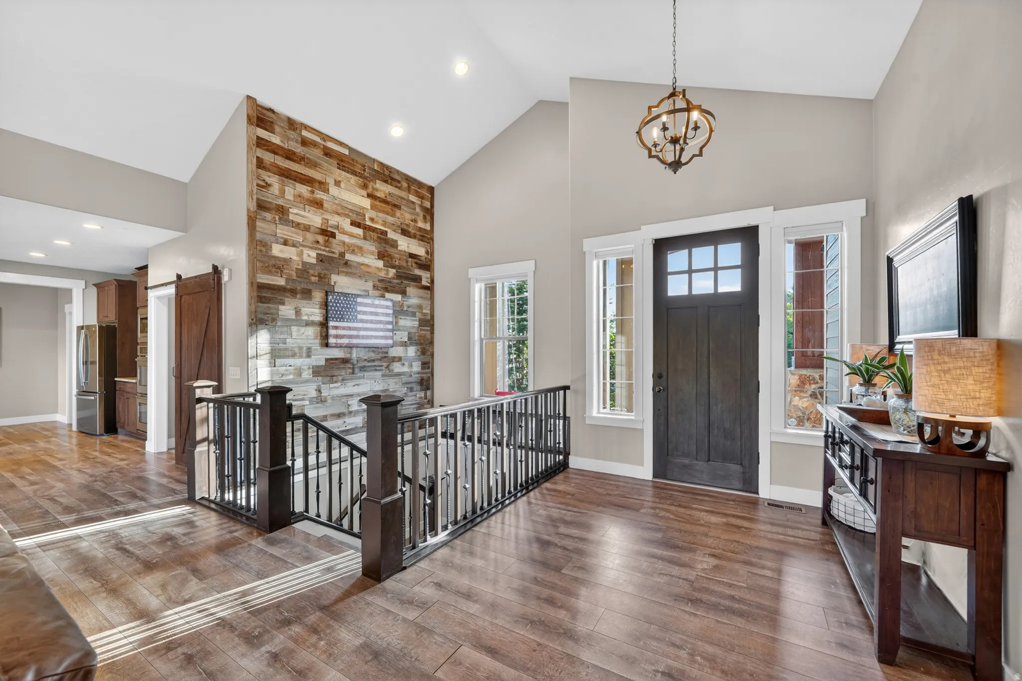 Vaulted entryway with wood-finish flooring