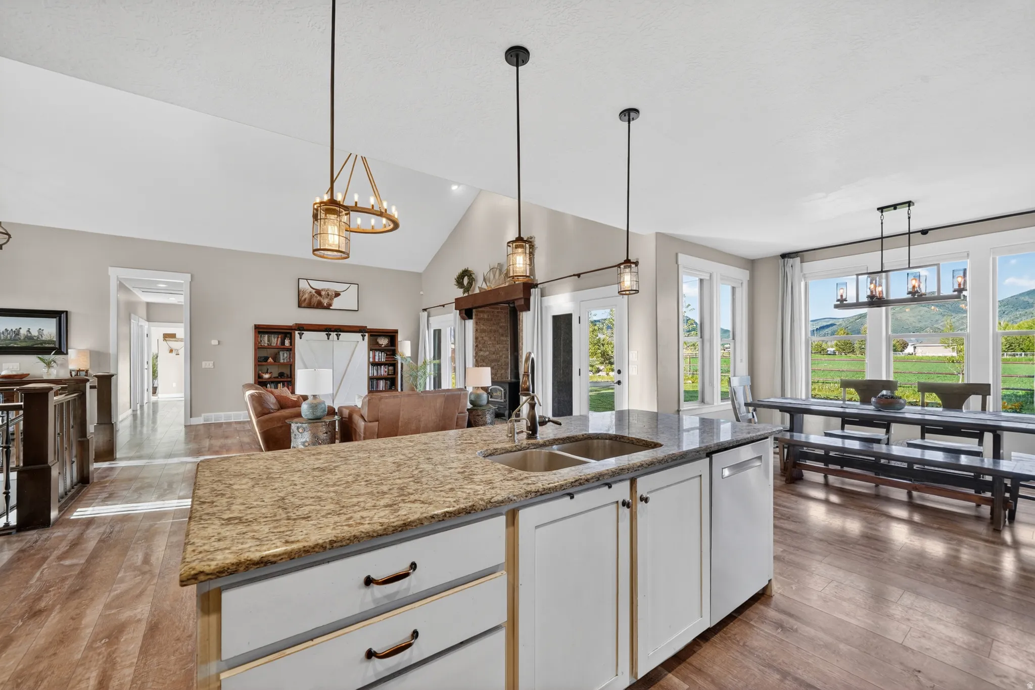 Kitchen island featuring a dual basin sink, integrated dishwasher, and granite-finish countertop