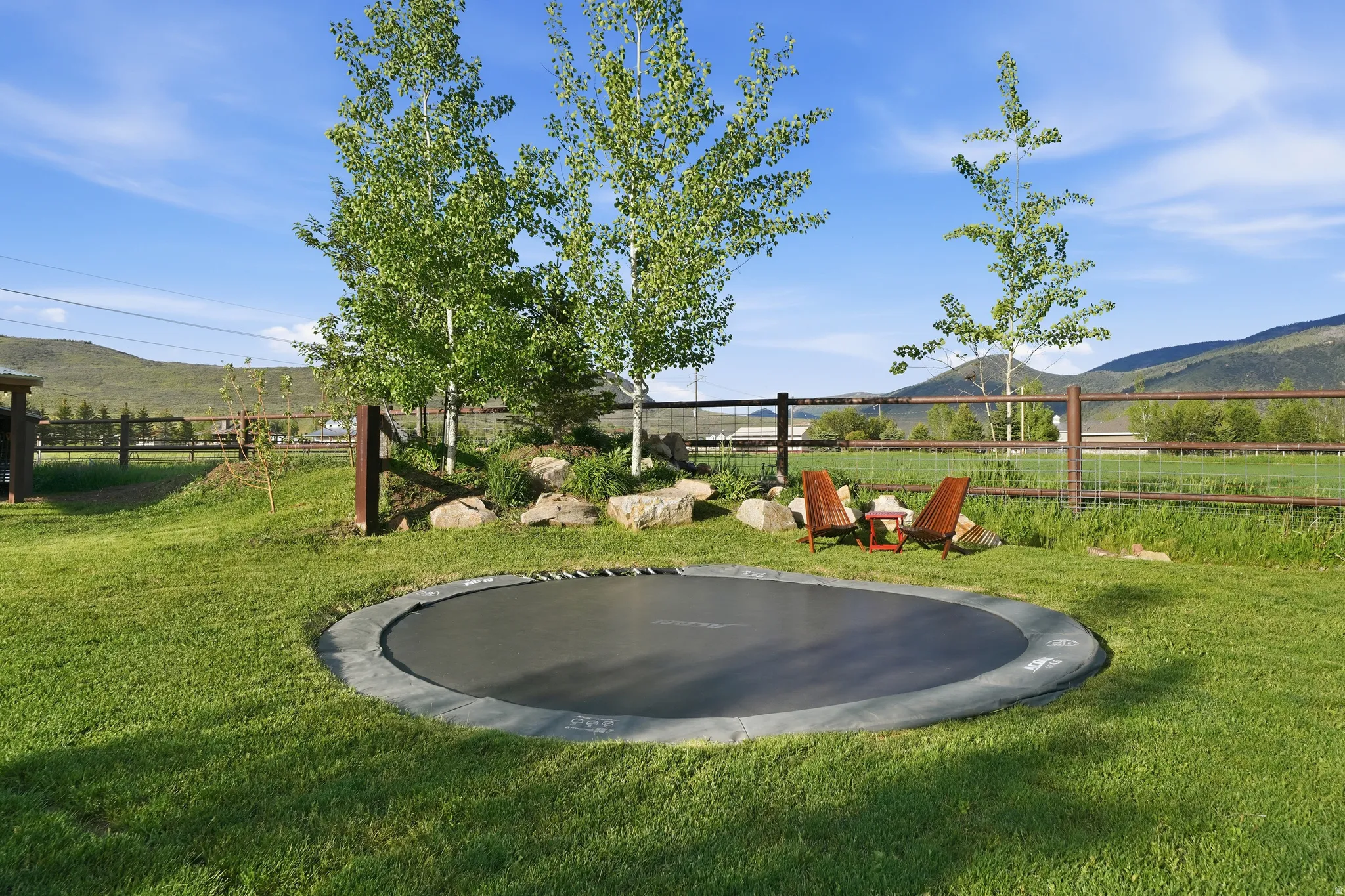 Expansive green lawn featuring an in-ground trampoline