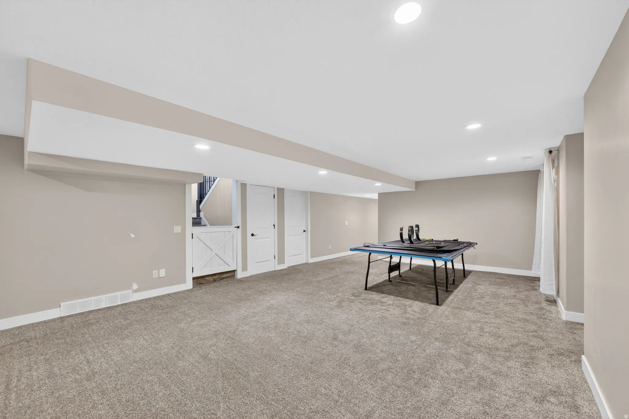 Expansive carpeted room featuring recessed lighting and neutral wall tones
