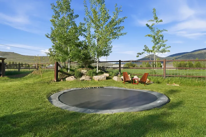 Expansive green lawn featuring an in-ground trampoline