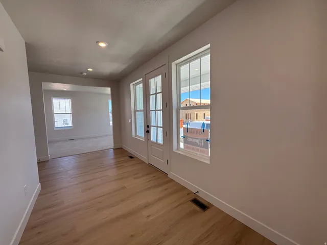 Entryway featuring wood-finish flooring, recessed lighting, and a glass-paneled entry door with sidelights