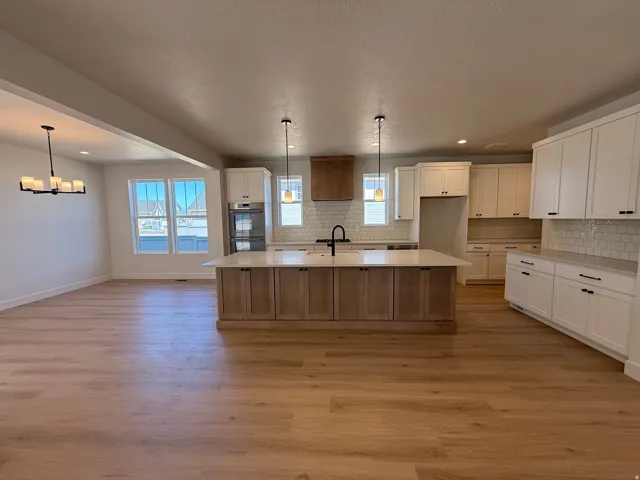 Open-concept kitchen and dining area featuring light wood-finish flooring