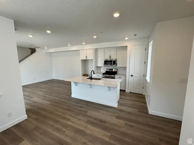 Modern kitchen island featuring a quartz countertop and integrated sink with a matte black faucet