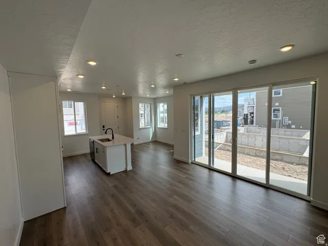 Open concept living area featuring wood-finish flooring, recessed lighting, and white walls