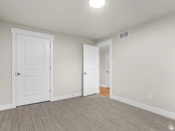 Room featuring light gray walls and a patterned gray carpet