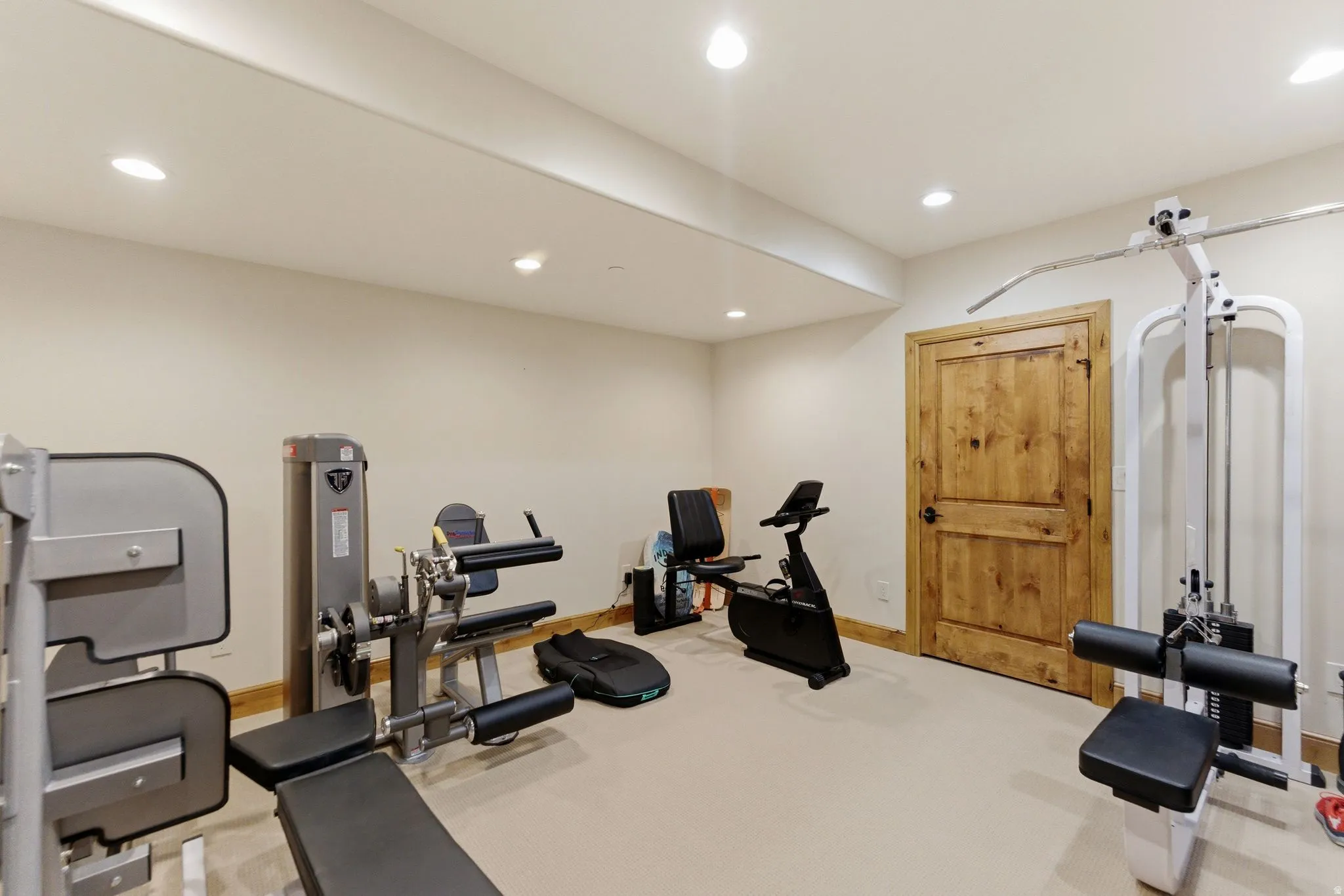 Dedicated fitness space featuring recessed lighting, light-toned walls, and wood-finish trim