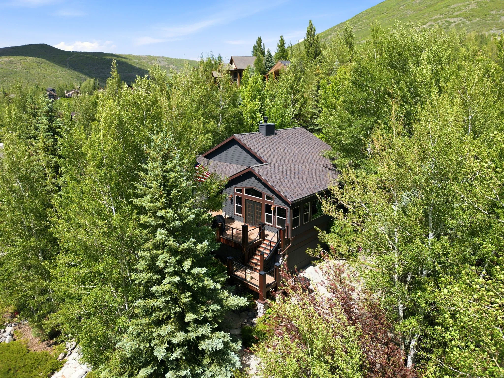 Two-story property featuring dark gray siding and a brown shingle roof